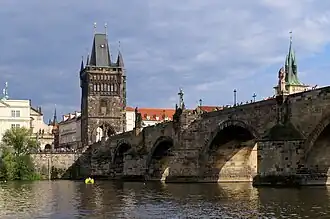 Torre del Puente de Carlos (1357-1402) en Praga, de Petr Parler, una de las mayores y más bellas puertas góticas de Europa.[36]​