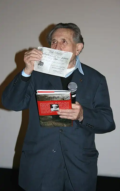 Adolf Burger, tipógrafo judío forzado a trabajar en la Operación Bernhard, mostrando uno de los billetes falsos.