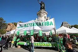 Una pequeña multitud con un cartel de Alternatiba.