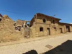 Vista de casa de adobe con arco de sillería en Amayuelas de Arriba.
