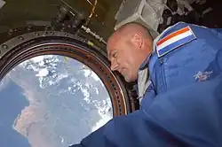 El astronauta neerlandés de la ESA André Kuipers mira a través de la ventana nadir del Destiny hacia la Tierra.