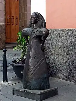 Escultura idealizada de Arminda Masequera, realizada por Diego Higueras en 2007 y situada frente al museo y parque arqueológico Cueva Pintada, en Gáldar.