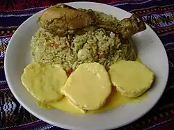 Arroz verde con pollo, acompañado de papa a la huancaína (Perú)