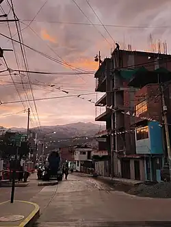 Se muestra un cielo anaranjado durante un atardecer en la ciudad de Huaraz, Perú. Fotografía con una montaña de fondo.