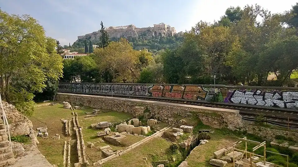 Leocoreion en el centro. Cruce de caminos del noroeste del ágora, en primer plano. Vía Panatenaica (izquierda).