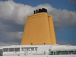 Los gases de escape del motor se expulsan a través de uno de los tubos de escape colocados en un embudo de un crucero moderno.