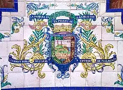 Escudo de la ciudad sobre azulejos en el Parque de Málaga.