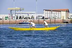 dos mujeres remando en un barco amarillo en un día soleado