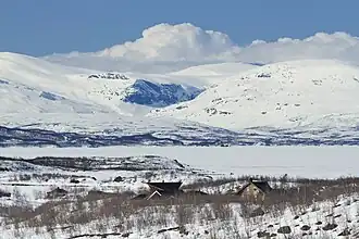 Vádvečohkka (derecha) y el profundo valle de Vádvejohka visto desde el sur en abril.