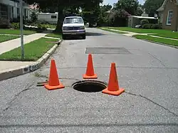 Trabajos en un pozo de visita señalizado