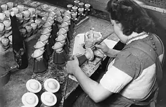 Artesano pintando a mano Räuchermänner en Seiffen (1947).