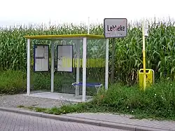 Esta parada en Bélgica cuenta con marquesina con techo, bancos, recorridos y horarios de las líneas de autobús y tacho de basura.