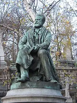 Estatua de Edmond About, decorando su sepultura en el cementerio de Père Lachaise en París.