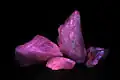 Calcita fluorescente en color rosa bajo luz ultravioleta.