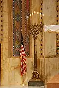 Candelabro junto a la bandera de los Estados Unidos.