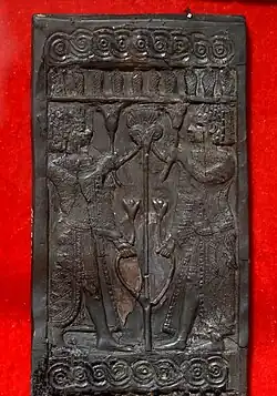 Panel de marfil tallado que muestra a jóvenes egipcios flanqueando el tallo y las flores de loto. De Nimrud, Irak. Museo de Irak.