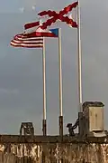 Cruz de Borgoña junto a las banderas de Puerto Rico y Estados Unidos en el Castillo San Cristóbal.