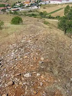 Vista de la muralla desde la parte superior de la misma a la altura de la puerta tapiada ante el asedio romano durante las guerras cántabras. Al fondo se ve el barrio de la Estación de Santibáñez de la Peña, donde se supone estaría ubicado uno de los campamentos legionarios durante el asedio
