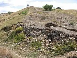 La muralla de la parte inferior del castro, donde se encontró una gran cantidad de puntas de flecha y de proyectiles metálicos pesados, de donde se deduce que esta fue la zona por donde se acometió el ataque más virulento a la muralla. Las hiladas detrás del derrumbe que están ordenadas, son las que delimitan el grosor de la muralla, alcanzando esta en torno a los 5 m de ancho