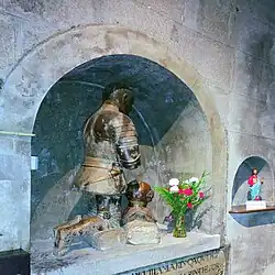 Sepulcro y estatua orante de un caballero con armadura y yelmo.