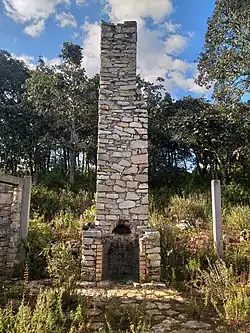 Restos de una chimenea del siglo XX cerca de la zona arqueológica de Monte Negro en Santiago Tilantongo, a sus costados se levantan postes de concreto que sirvieron de soporte a una casa