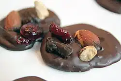 Dos mendiant, hechos con chocolate negro y frutos secos.