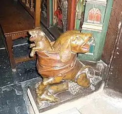 Perro de dos caras en la base de la puerta del coro