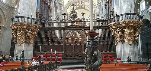 Reja del coro flanqueada por las tribunas superiores.