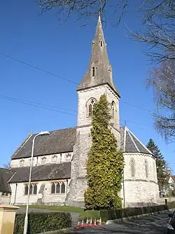 Christ Church (1861), Winchester, Hampshire, showing the south-east tower and broach spire and the polygonal chancel apse. The church has a striking clerestory with cinquefoil windows[PL 1]​