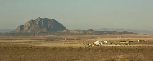 La cara SE del Almorchón domina un extenso terreno agrícola hasta las sierras del Oro y de Ricote