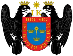 Escudo de armas de Lima con los símbolos de los descendientes de los reyes católicos, Juana y Carlos, iniciales I y K, y dos águilas de San Juan.