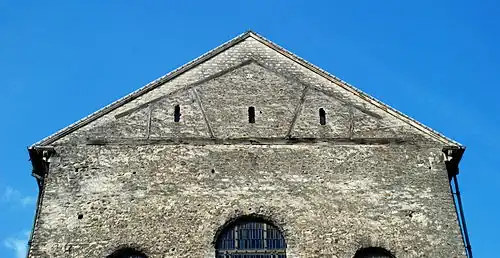 La cercha de cubierta empotrada en el piñón de la cabecera