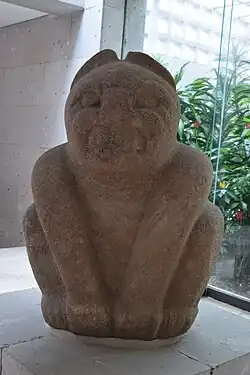 Escultura de basalto de un jaguar olmeca. Su rostro se encuentra algo erosionado. En el fondo se observan los pisos del Museo de Antropologia de Xalapa