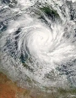 Vista satelital de un ciclón tropical grande y bien desarrollado cerca del norte de Queensland. Un ojo pronunciado pero lleno de nubes y bandas de lluvia curvas marcan las características de una tormenta madura.