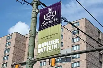 Banderola con el logotipo de Dunder Mifflin frente al ayuntamiento de Scranton.