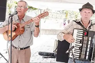 Presentación de un dúo interpretando el joropo coloniero, expresión musical que combina la tradición del joropo venezolano con influencias melódicas y rítmicas de la música folclórica alemana.