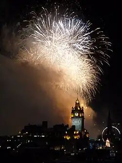 fuegos artificiales en un cielo oscuro con un catedral grande visible