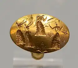 Anillo-sello de oro grabado con figuras femeninas.