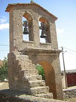 Espadaña de la iglesia de San Pedro de la Nave, situada sobre la cerca que rodea la iglesia.