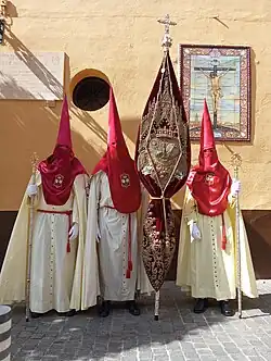 Estandarte Corporativo de la hermandad junto a nazarenos de la misma