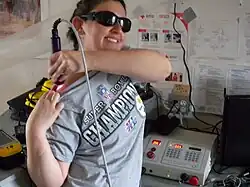 Crew member Kristine Ferrone operates a Class IV High Power Laser therapy device.