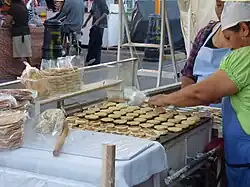 Mujer preparando gorditas de nata.