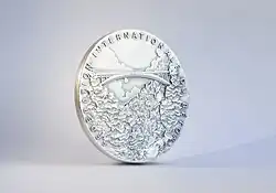 La foto muestra una fotografía de la "Medalla al Mérito en fibra" de la Fédération internationale du béton