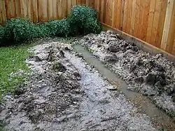 Un desagüe francés en construcción después de una lluvia (tenga en cuenta que la parte trasera de la zanja aún no se ha excavado).