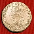 Reverso de una moneda de plata de 3 florines de 1696 acuñadas en Leeuwarden con la leyenda en latín de HANC TUEMUR, HAC NITIMUR ("La protegemos; nos apoya"), mostrando a la doncella sosteniendo una lanza que en lo alto sostiene un gorro frigio y en la mano izquierda una biblia y apoyándose en un altar.
