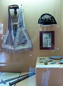 Vitrina con daga española, estola de brocato e hilos de plata, bolso de dama, mujer de ascendencia española habitante de Chiloé, cerámica española