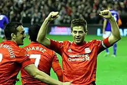 Steven Gerrard, capitán del Liverpool F. C., festeja un tanto con los fans en Anfield.
