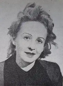 Imagen en blanco y negro de la cabeza de una mujer con pelo más bien corto, tirando a claro y un poco despeinada parece que por el viento. Tiene las cejas muy finas.