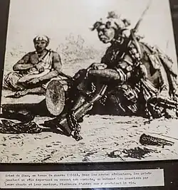 Foto de un griot en traje de guerra (1866).