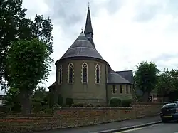 Iglesia de la Santísima Trinidad (1865) Lyonsdown Road, New Barnet, Londres, mostrando el fuerte ábside del presbiterio en stock brick con bandas de ladrillo rojas[CP 3]​